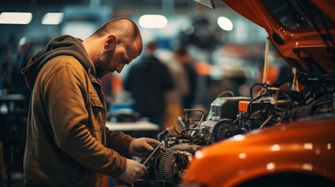 A mechanic working in a busy automotive service station, attended by customers.