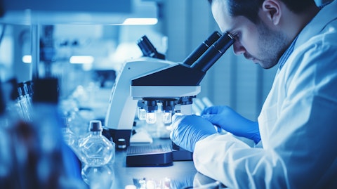 A researcher studying cellular therapeutics under a microscope.