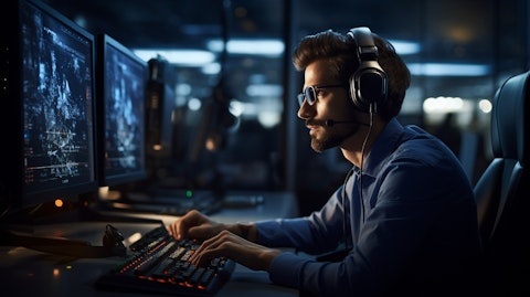 An IT professional wearing a headset and using a keyboard while working in a secure environment.