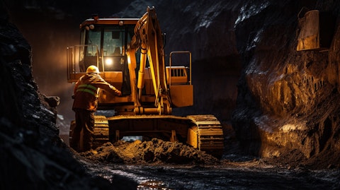 A worker in full safety gear operating an excavator in a mining operation.