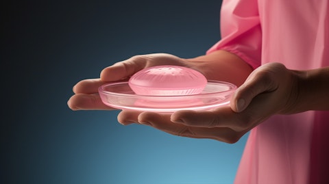 A helping hand holding a 3D bioprinted breast implant above a surgical tray.