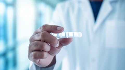 A close-up of a hand holding a vial of biopharmaceutical drugs ready to be administered.