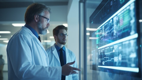 A healthcare professional wearing a health communications device discussing patient data with a colleague.