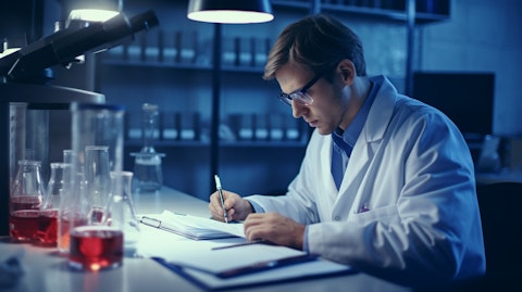 A researcher analyzing blood test results and recording data in a lab notebook.