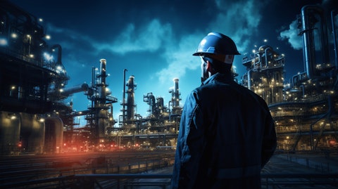 A engineer overseeing a exposed network of pipelines connected to tanks at an oil refinery.
