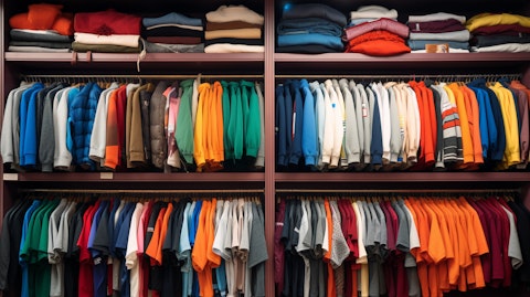 A store shelf lined with t-shirts, jackets and pullovers.