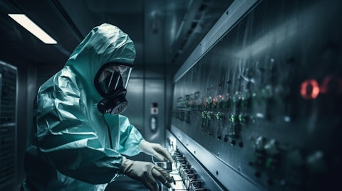 A technician in a protective suit entering a decontamination chamber.
