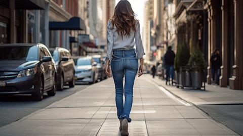 A fashion-forward woman walking confidently down the street wearing the company's latest denim jeans.